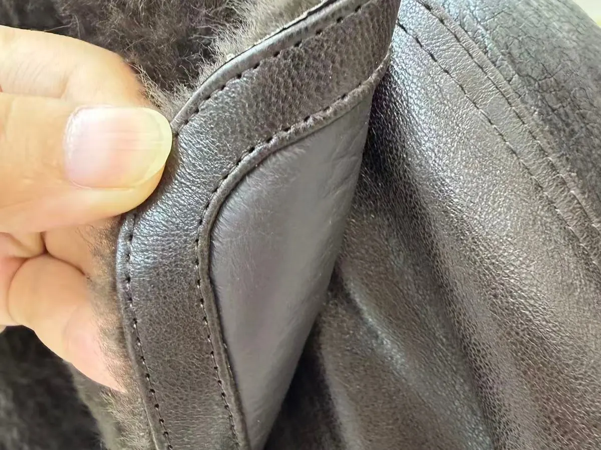 Fur-to-leather seam stitching detail — OEM fur jacket manufacturing quality