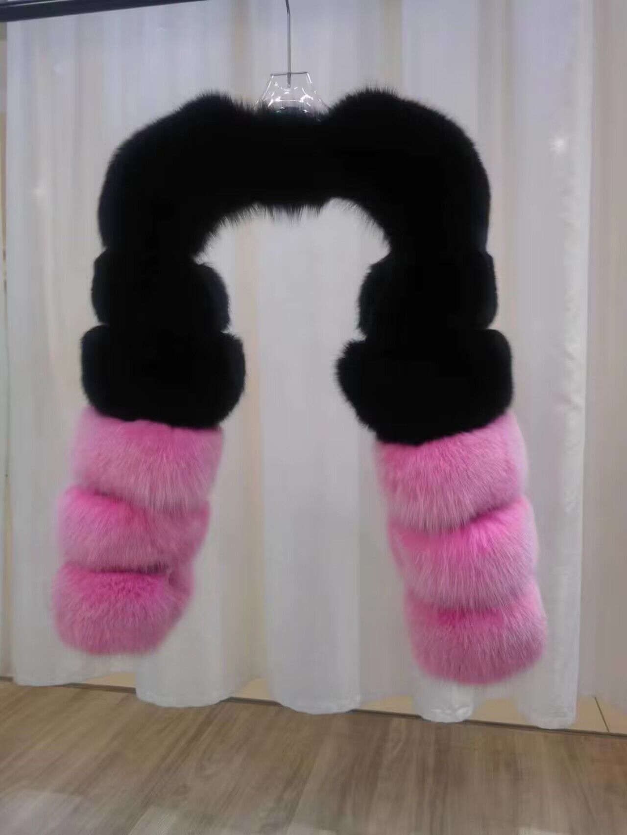 Black and pink connected shoulder-and-sleeve accessory on a hanger