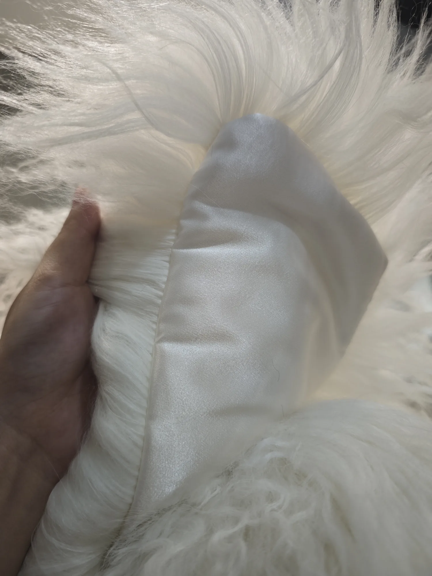 Close-up comparison of white curly lamb fur texture and smooth satin jacket lining