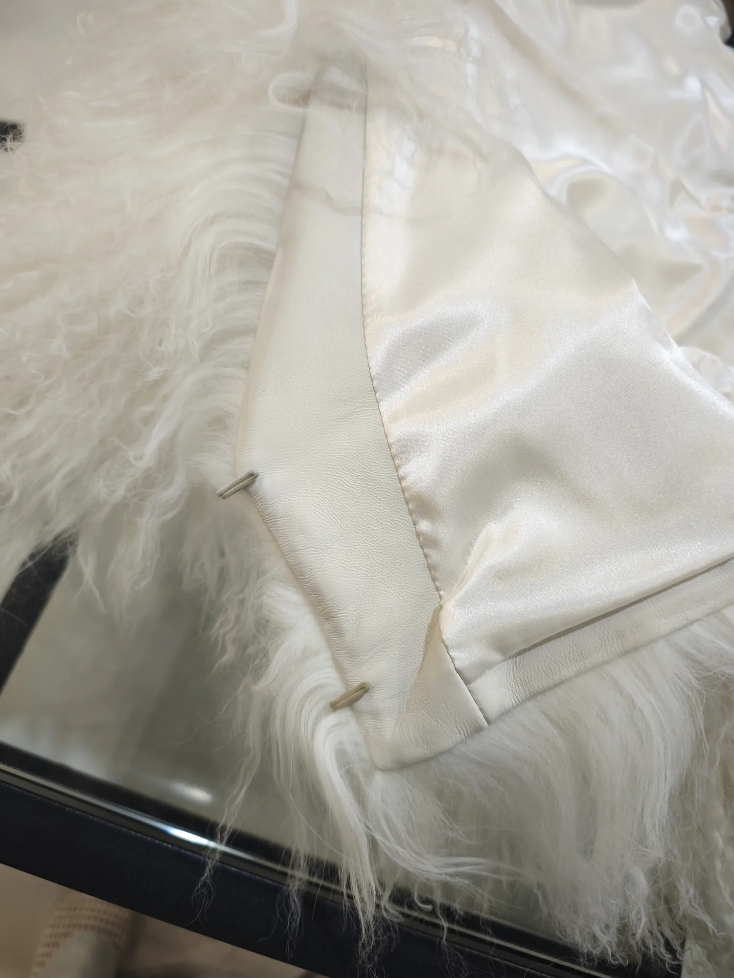 Original close-up showing curly-lamb pile, leather facing, corded loop and satin lining